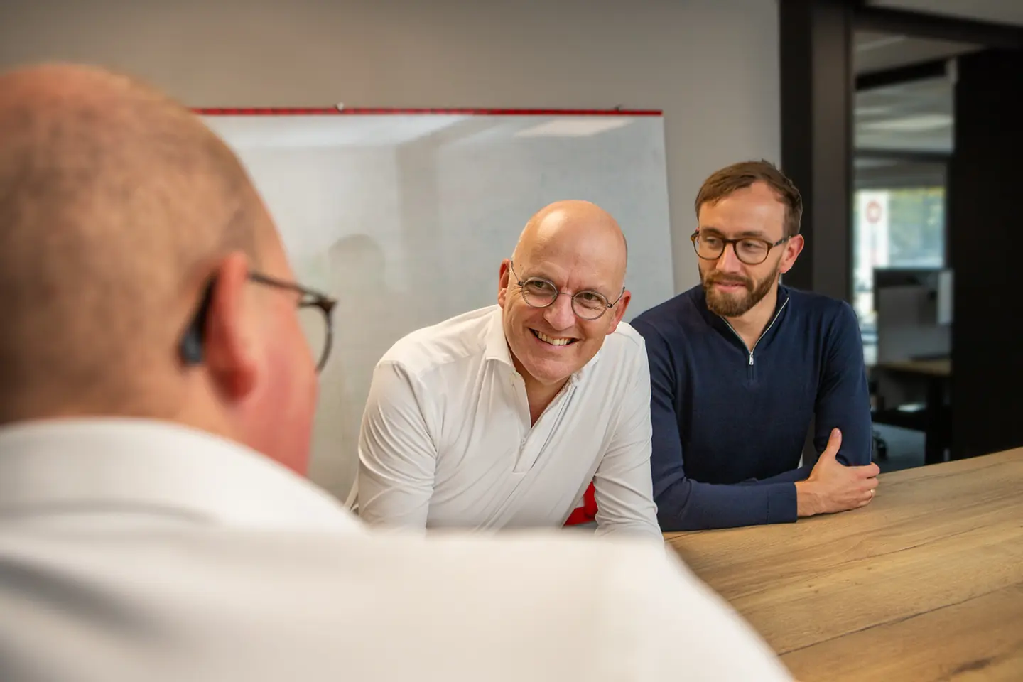 Drie collega's van Orange Bits in gesprek aan de vergadertafel